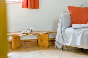 Ein Zimmer mit einer Holzbank, einer weißen Tasse und einem Teller Kekse.