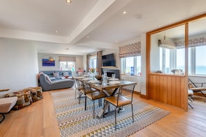 A spacious living area with a dining table, sofa, and a television. - 4 Bed in Hunstanton (oc-t44905) (Hunstanton)