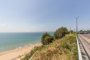 Eine Küstenstraße mit Strand und freiem Blick auf das Meer.