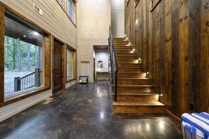 Lit stairs and reclaimed wood walls make every floor feel like a retreat. - The Cedarwood Collective · Indoor Pool, Theatre, Putt-Putt & Gameroom | Sleeps 27! (Broken Bow)