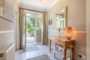 A room with a wooden desk, a large mirror, a radiator, and a door leading to a garden. - 4 Bed in Chesterfield (oc-w45546) (Chesterfield)