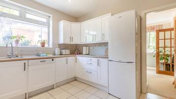 A modern kitchen with white cabinetry, a dishwasher, and a refrigerator.