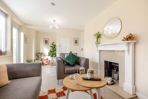 A living room with a fireplace, a sofa, a coffee table, and a remote control. - 3 Bed in Leek (oc-l45949) (Leek)