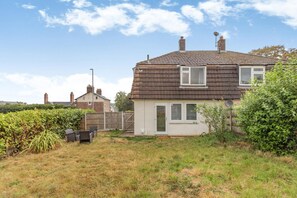 A single-story house with a tiled roof, a front door, and a small garden area with a fence and shrubs. - 3 Bed in Leek (oc-l45949) (Leek)