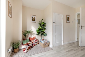 A hallway with a patterned rug, a door, and a plant. - 3 Bed in Leek (oc-l45949) (Leek)