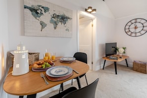 Ein Essbereich mit einem Holztisch, Tellern, einem weißen Laternen und einer Weltkarte an der Wand.