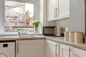 A kitchen with a built-in dishwasher, a microwave, and a window with a view of the outside. - 2 Bed in Buxton (oc-p45950) (Buxton)