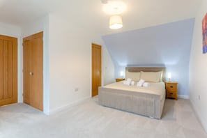 Un dormitorio con una cama, dos mesitas de noche, una lámpara y una lámpara del techo.