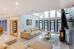Una sala de estar amplia con un sofá, una mesa de centro y una chimenea.