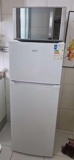 Ein weißer Kühlschrank mit digitaler Anzeige und Bedienfeld auf der Oberseite.