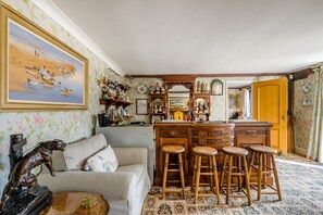 Une pièce comprenant un coin bar, un canapé et un tapis à motifs.