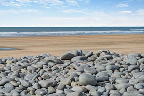 A beach with a rocky foreground and a sandy beach in the background. - 3 Bed in Westward Ho (oc-h45910) (Northam)