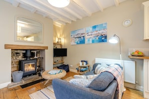 A cozy living room with a fireplace, a sofa, a television, and artwork on the wall. - 1 Bed in Robin Hoods Bay (oc-o45887) (Robin Hood's Bay)