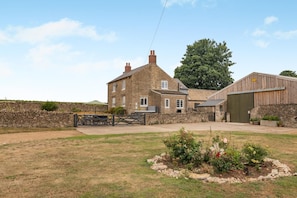 A stone building with a large tree, a fenced garden, and a wooden barn. - 4 Bed in Ebberston (oc-h45939) (Ebberston)