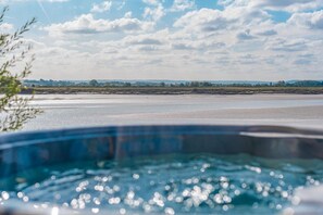 Ein Whirlpool mit Blick auf einen Strand und die Küste in der Ferne.