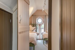 Ein Schlafzimmer mit zwei Betten, einem Dachfenster und Blick ins Freie.