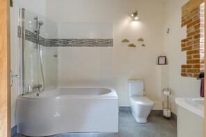Ein Badezimmer mit einer Duschkabine, einer weißen Toilette und einem Waschbecken.
