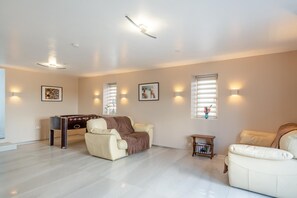 A spacious living room with a pool table, two sofas, and wall-mounted lighting. - 5 Bed in Cerrigydrudion (oc-c45945) (Cerrigydrudion)