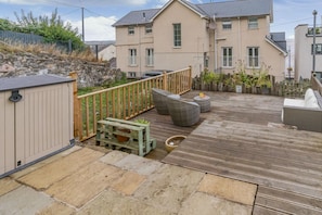 A residential property with a paved patio, outdoor seating, and a stone wall. - 2 Bed in Mumbles (oc-c45992) (The Mumbles)