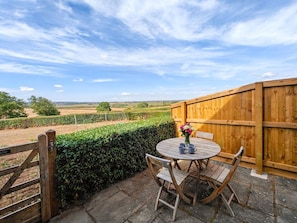 A wooden table and chairs on a patio with a view of a field and a wooden fence. - 2 Bed in North Curry (oc-c45884) (North Curry)