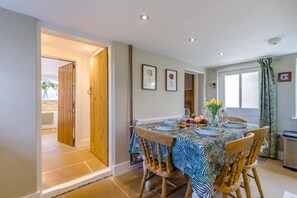 A dining area with a round table set for four, surrounded by wooden chairs. - 3 Bed in Ingham (oc-h45928) (Ingham)