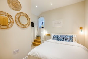 A bedroom with a bed, a wall-mounted mirror, a framed inspirational quote, and a staircase leading to a balcony. - 3 Bed in Sparham (oc-f46029) (Lyng)