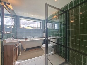 A bathroom with a freestanding bathtub, a toilet, and a sink. - 3 Bed in Skilgate (oc-w46009) (Skilgate)