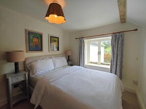 A bedroom with a bed, two bedside tables, a window with curtains, and a hanging lamp. - 3 Bed in Skilgate (oc-w46009) (Skilgate)
