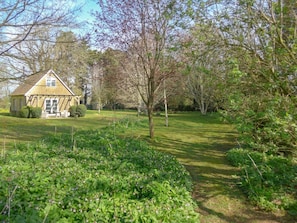 Ein Haus mit Garten, Rasen und einem kleinen Teich.