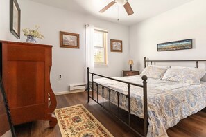 A bedroom with a bed, a nightstand, a dresser, a window, and a ceiling fan. - Wonderful 3-bedroom house with AC in charming Lake Harmony (Lake Harmony)
