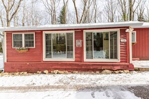 A red cabin with large windows, a mailbox, and a number sign. - Wonderful 3-bedroom house with AC in charming Lake Harmony (Lake Harmony)