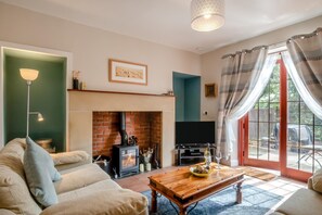 A living room with a fireplace, a sofa, a coffee table, and a television. - 2 Bed in Berwick-upon-Tweed (oc-s46040) (Kyloe)