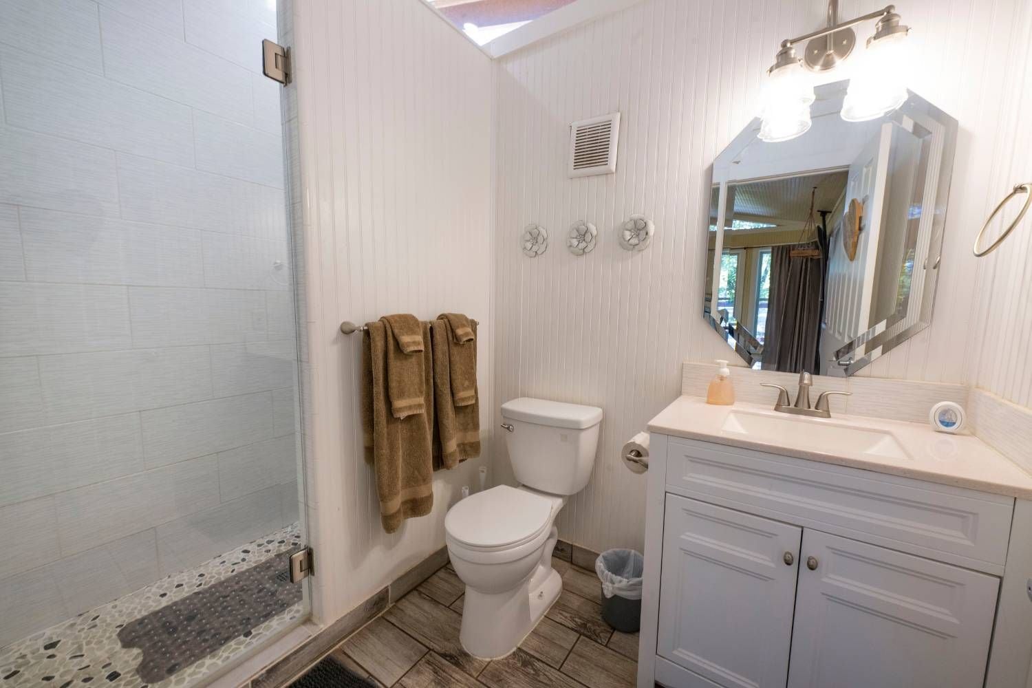 A bathroom with a toilet, sink, and shower area.