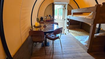A cozy interior with a wooden table, chairs, and a bunk bed.