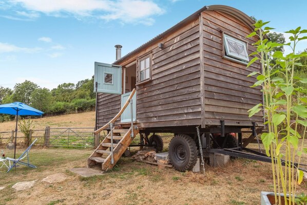 Een houten stacaravan met een hellingbaan en een klein terras.