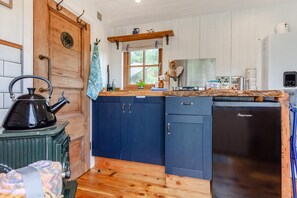A compact kitchen with a stove, a refrigerator, and wooden cabinets. - 1 Bed in Batheaston (oc-f45918) (Batheaston)