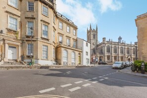A street with historic buildings, including a church with a clock tower. - 1 Bed in Bath (oc-r45717) (Bath)