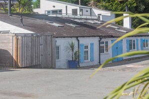 A building with a sloped roof, a wooden fence, and a potted plant. - 1 Bed in Abersoch (oc-l46031) (Abersoch)
