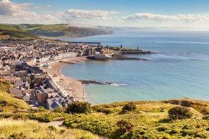 A coastal town with a prominent castle, a curved bay, and a view of the sea. - 3 Bed in Talybont (oc-b46034) (Llandre)