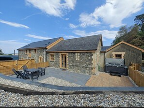 A stone building with a patio area, outdoor seating, and a barbecue grill. - 3 Bed in Talybont (oc-b46034) (Llandre)