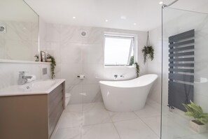 A modern bathroom with a freestanding bathtub, a large mirror, and a glass shower enclosure. - 7 Bed in Earswick (oc-s46053) (Earswick)