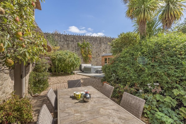 Un patio con mesa, sillas y un jacuzzi.