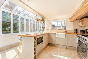 A kitchen with a large island, a built-in oven, and a view through the windows. - 2 Bed in Thrussington (oc-42472) (Thrussington)