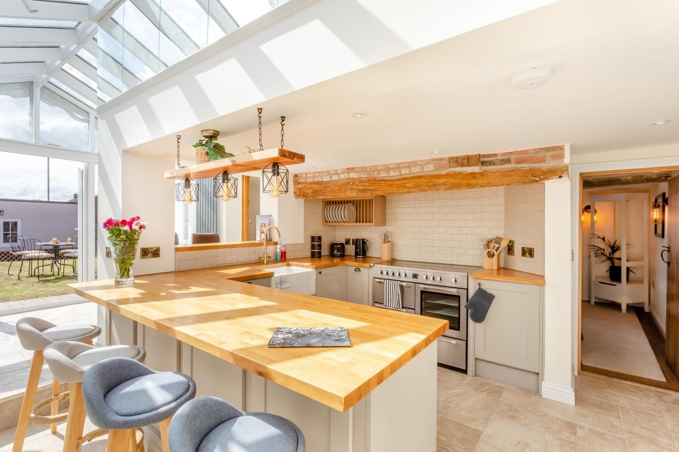 A modern kitchen with a large island, stainless steel appliances, and a skylight.