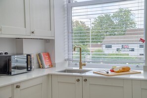 A kitchen with a built-in toaster, a sink, and a window with blinds. - 2 Bed in Chipping Sodbury (oc-r45995) (Chipping Sodbury)