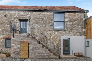 A stone building with a wooden staircase, a door, and a window. - 2 Bed in Chipping Sodbury (oc-r45995) (Chipping Sodbury)