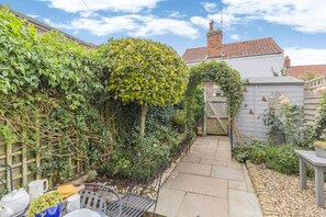 A garden with a paved pathway, a wooden fence, and a variety of plants. - 1 Bed in Holt (oc-a46046) (Holt)