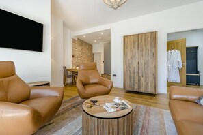 A modern living room with leather sofas, a coffee table, and a stone accent wall.