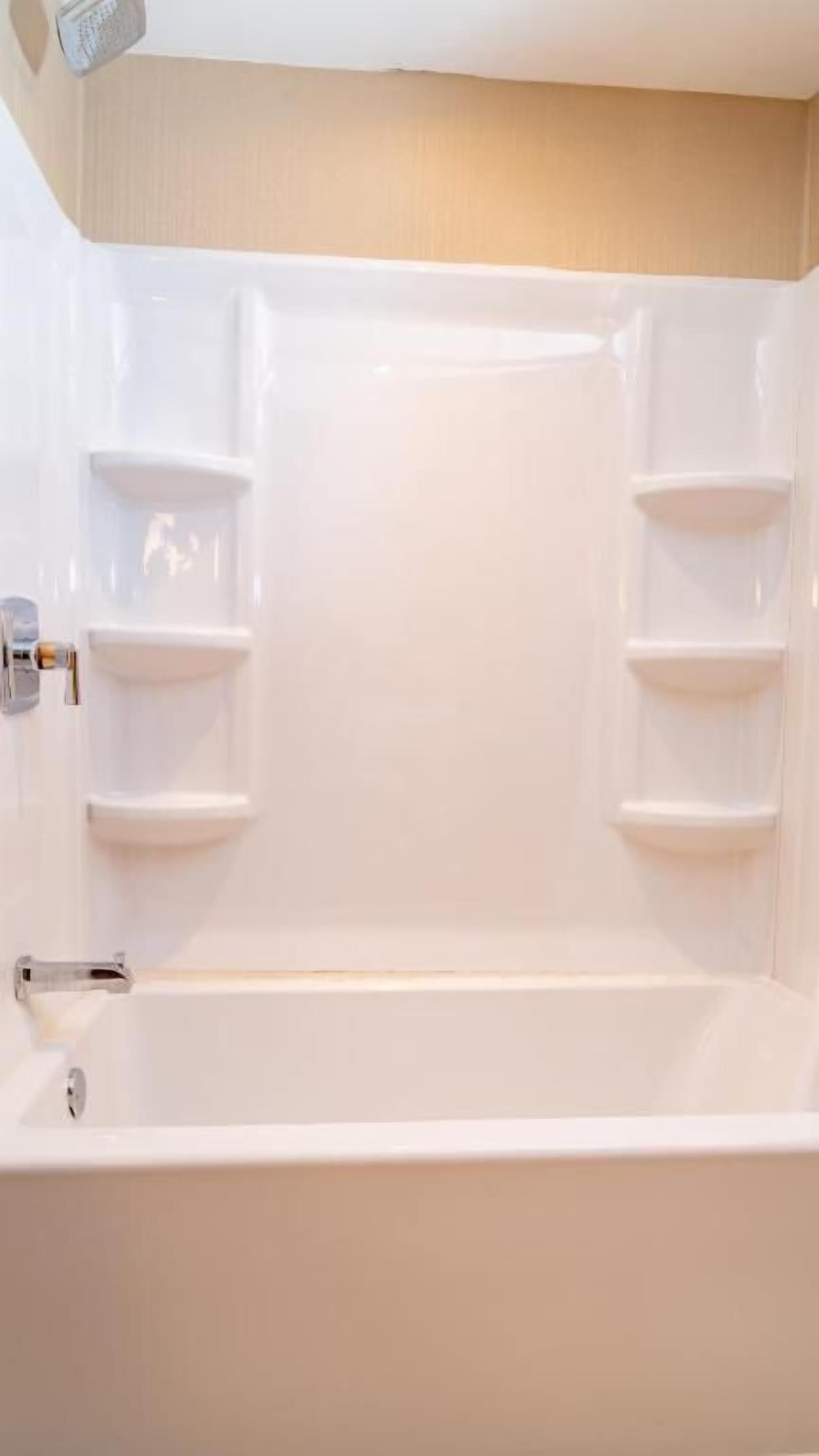 Une baignoire dotée d’étagères intégrées et d’un robinet.