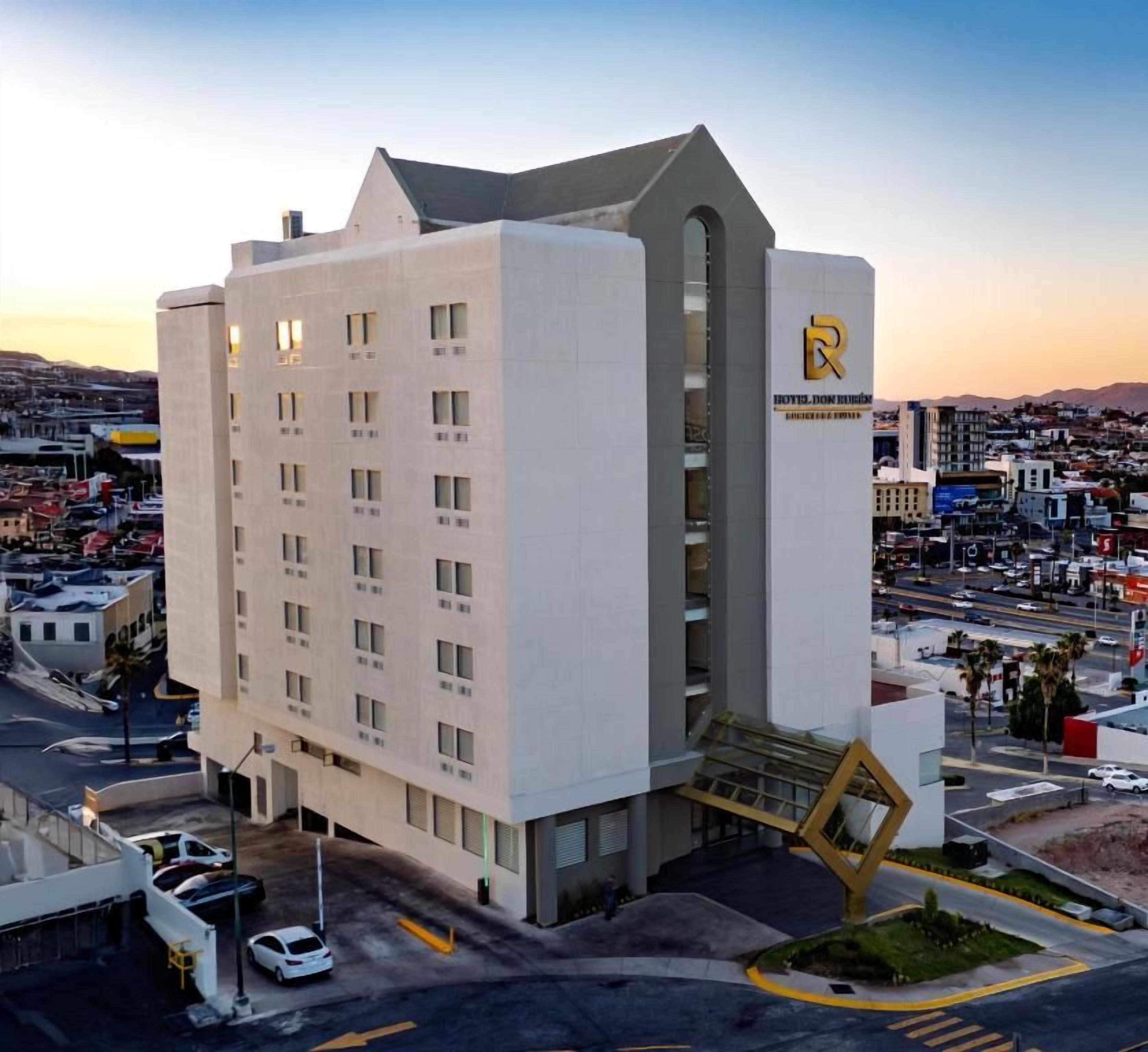 A modern hotel with a prominent 'R' logo, multiple floors, and a central staircase.